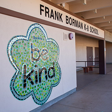 A mural, Be Kind is proudly displayed at the entrance to Frank Borman K-8 school.
