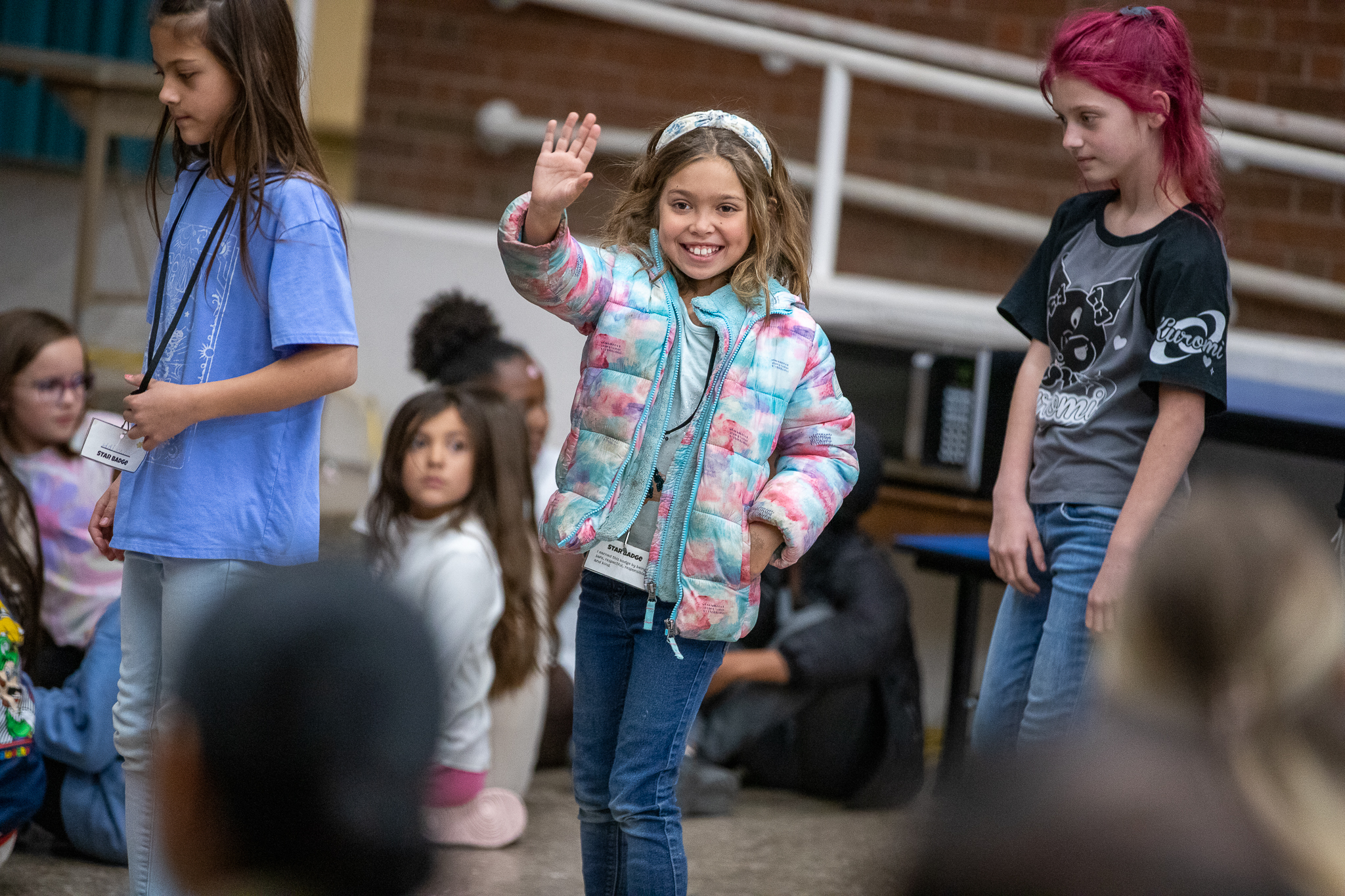 A little girl waves to the crowd