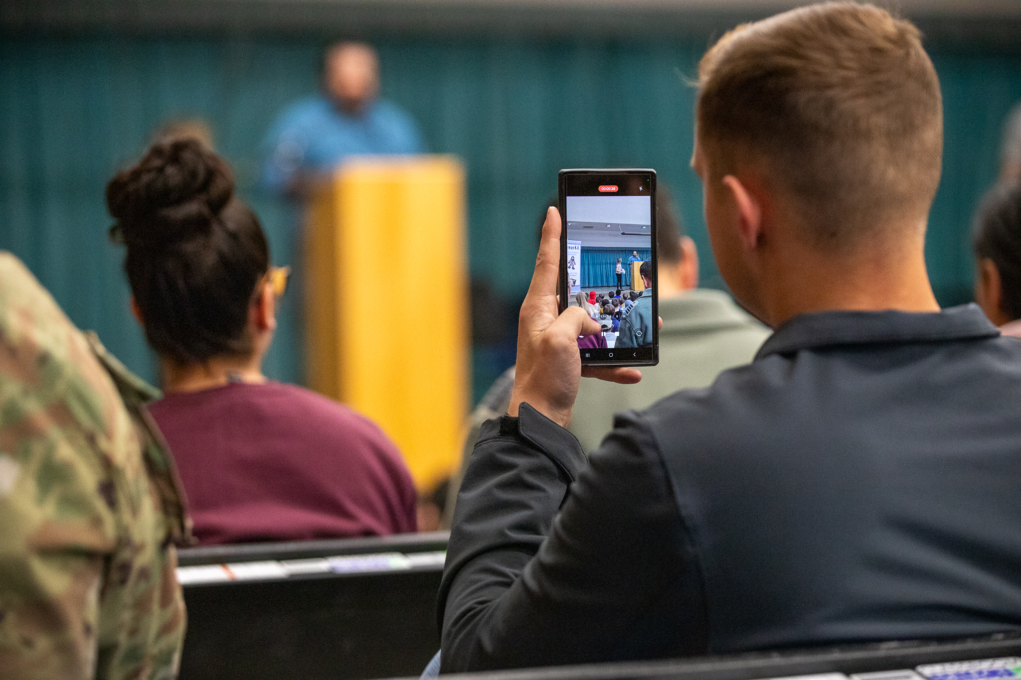 A dad records the award ceremony on his phone