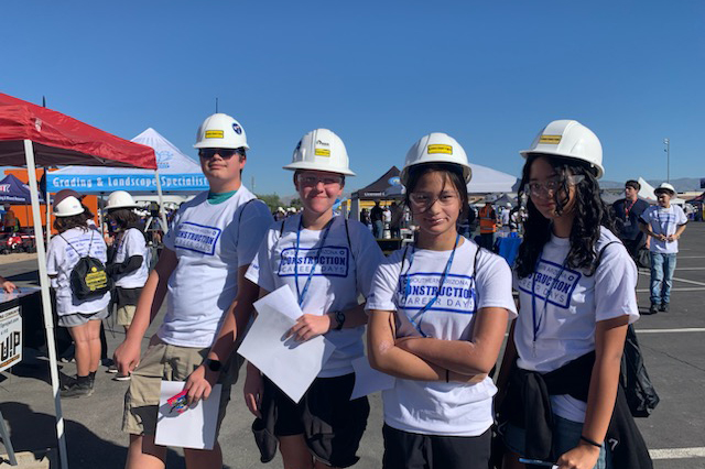 Four students in hard hats pose for a photo