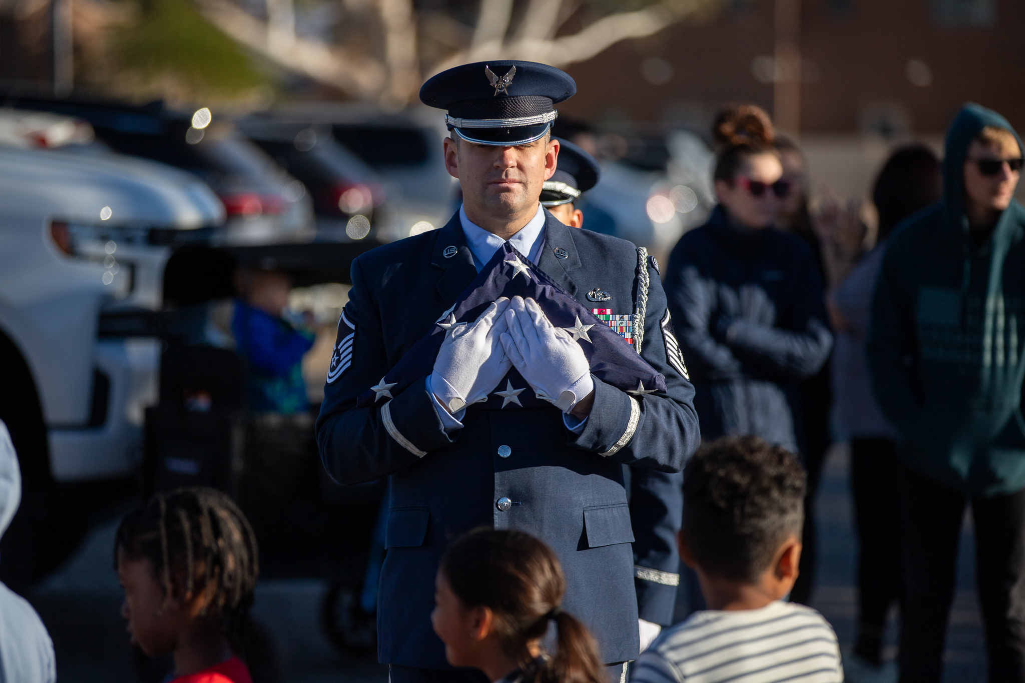 A military service member holds a folded American flag