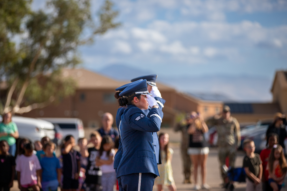A group of people in military uniforms stand in a line saluting