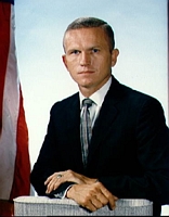 Portrait photo Astronaut Frank Borman in a business suit, with a blue sky and American flag behind him